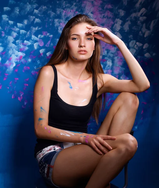 Fiatal nő ül festészet fal közelében — Stock Fotó