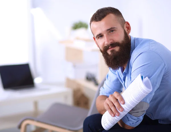 Young businessman sitting on chair with book in office — Stock Photo, Image