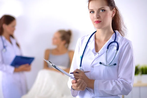 Smiling female doctor with a folder in uniform standing at hospital Royalty Free Stock Images