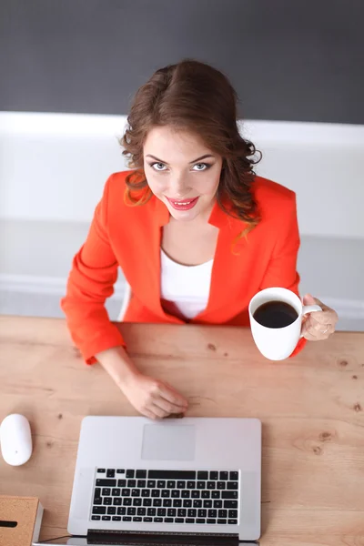 Mulher atraente sentada na mesa no escritório, trabalhando com computador portátil — Fotografia de Stock