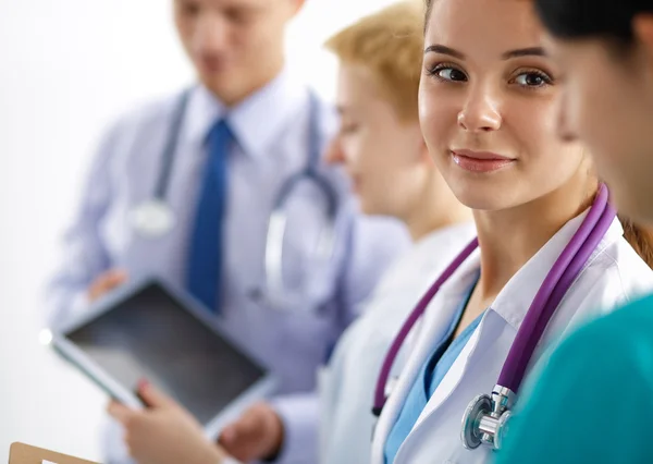 Attraktiv kvindelig læge foran medicinsk gruppe - Stock-foto