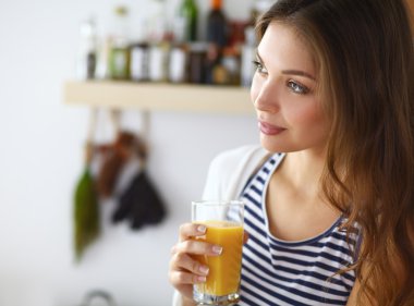 Lezzetli meyve suyuyla bardağı tutan güzel bir kadının portresi.