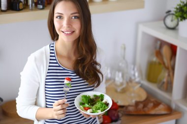 Salata yemek ve karışık salata tutan genç kadın 