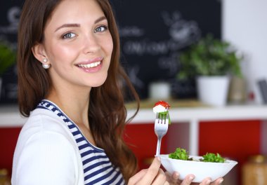 Salata yemek ve karışık salata tutan genç kadın 