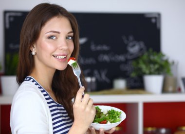 Salata yemek ve karışık salata tutan genç kadın 