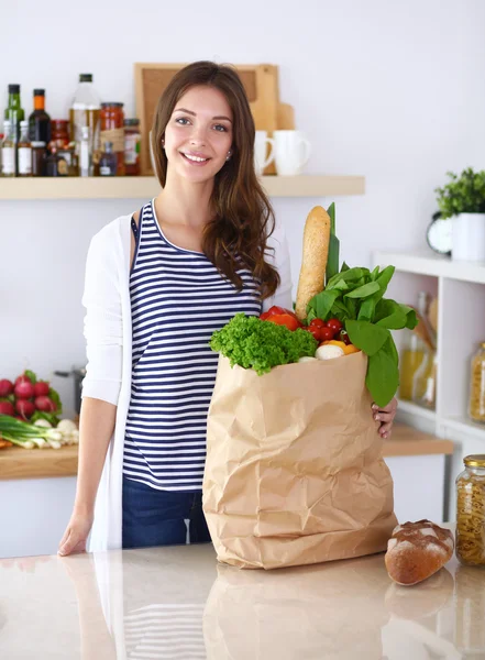 Jonge vrouw staat in de keuken thuis — Stockfoto