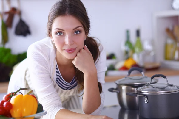 Young woman standing near desk in the kitchen — Stock Photo, Image