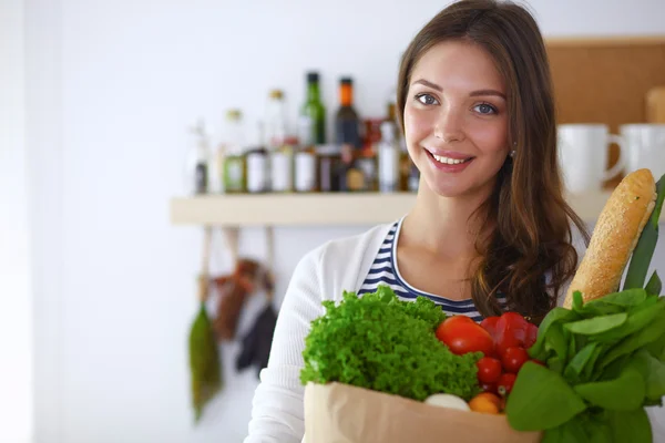 Young woman holding grocery shopping bag with vegetables — Stock Photo, Image