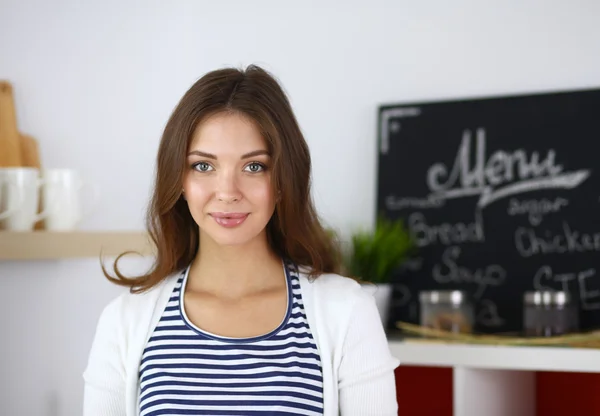 Giovane donna in piedi in cucina a casa — Foto Stock