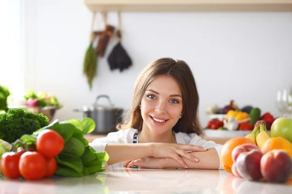 Jovem mulher de pé perto da mesa na cozinha — Fotografia de Stock