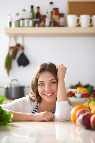 Jonge vrouw in de buurt van bureau in de keuken — Stockfoto