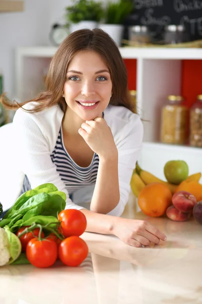 Jonge vrouw in de buurt van bureau in de keuken — Stockfoto