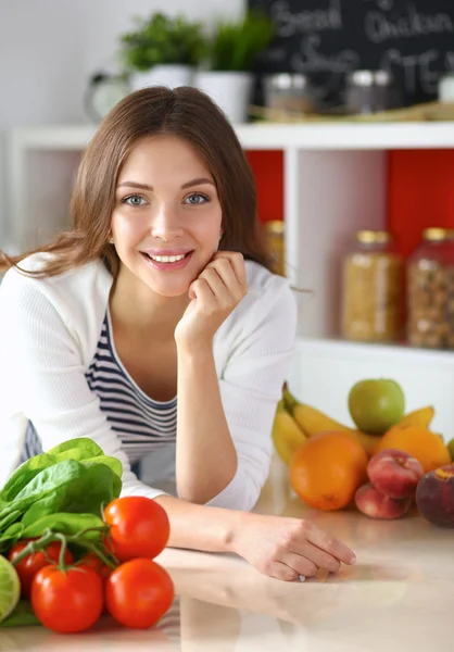 Jonge vrouw in de buurt van bureau in de keuken — Stockfoto