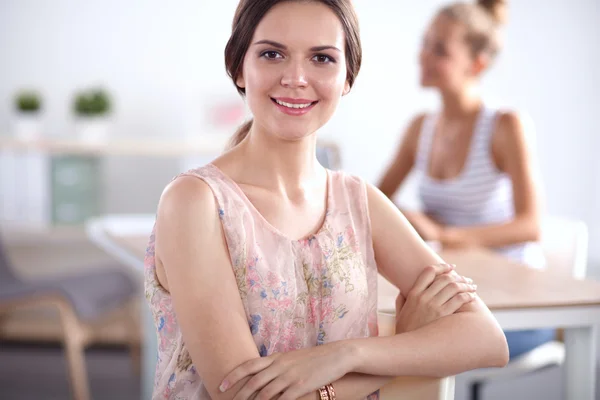 Attractive businesswoman sitting  on desk in the office — Stock Photo, Image
