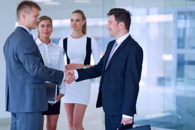 İki başarılı iş adamının el sıkışırken tam boy görüntüsü.