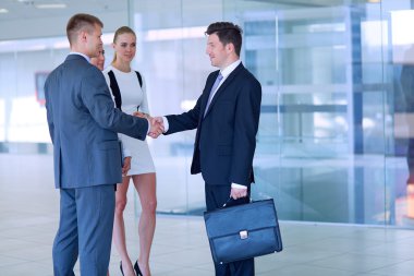 İki başarılı iş adamının el sıkışırken tam boy görüntüsü.