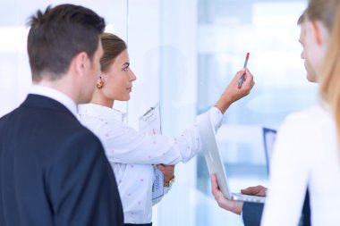 Toplantı sırasında dizüstü bilgisayarla sunum yapan bir grup iş adamı