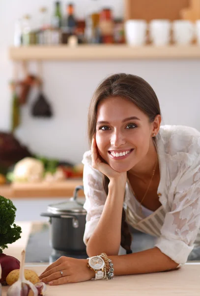 Jonge vrouw in de buurt van bureau in de keuken — Stockfoto