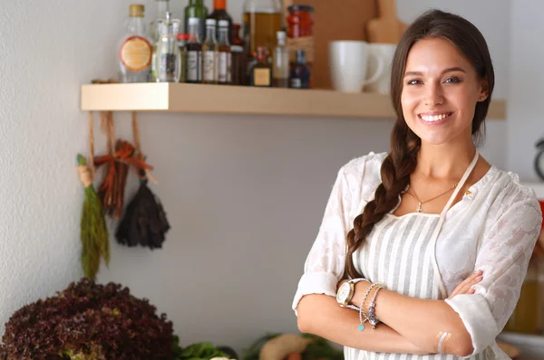 Jovem mulher de pé perto da mesa na cozinha — Fotografia de Stock