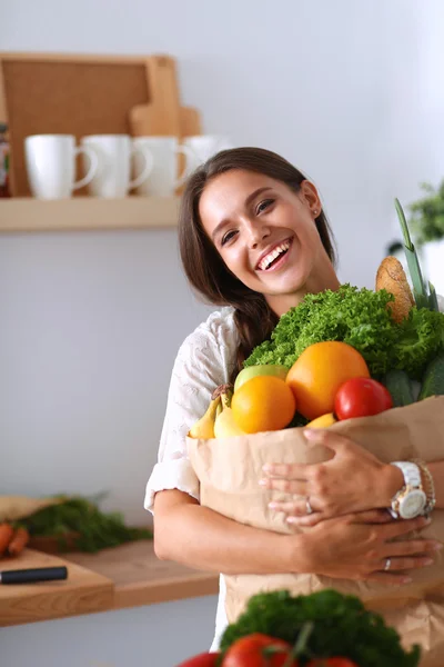 Ung kvinna som håller i matkassen med grönsaker — Stockfoto