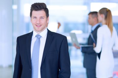 arka planda meslektaşları ile Office genç işadamı portresi