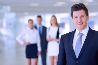arka planda meslektaşları ile Office genç işadamı portresi