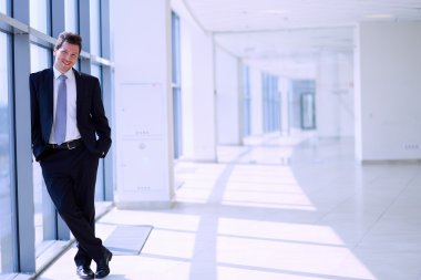 Ofisteki pencerenin yanında duran işadamının portresi