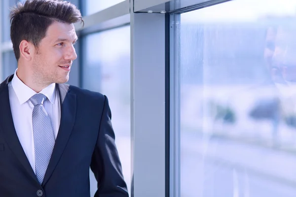 Portret van een zakenman in de buurt van een raam in het kantoor — Stockfoto