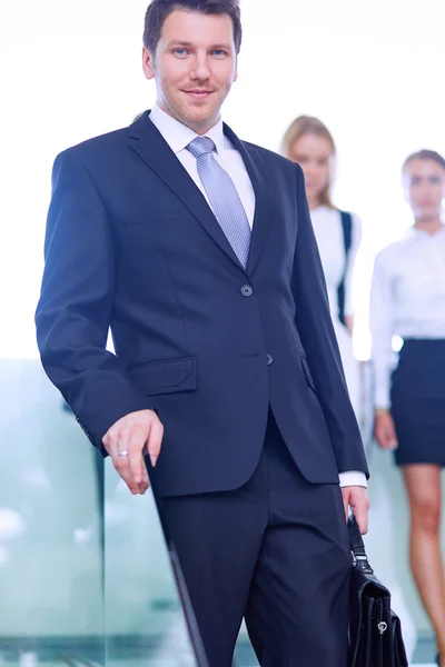 Retrato de un joven empresario en el cargo con colegas en segundo plano — Foto de Stock