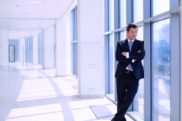 Porträt eines Geschäftsmannes, der am Fenster seines Büros steht — Stockfoto