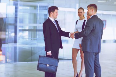 İki başarılı iş adamının el sıkışırken tam boy görüntüsü.