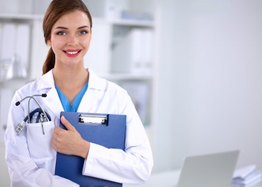 Hastanede üniformalı, gülümseyen bir kadın doktor.