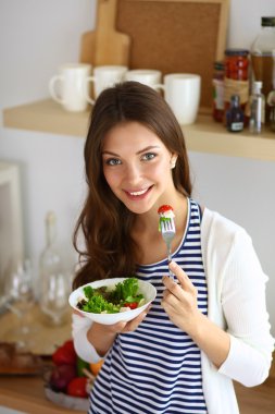 Salata yemek ve karışık salata tutan genç kadın 