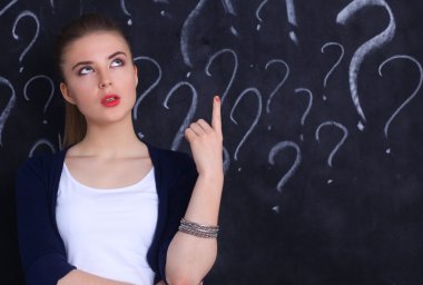 soru işareti gri bir arka plan üzerinde bulunan genç kız