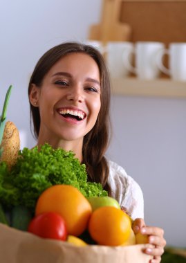 Bakkal alışveriş çantası sebze ve meyve tutan genç kadın