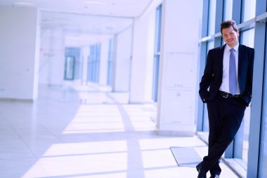 Ofisteki pencerenin yanında duran işadamının portresi