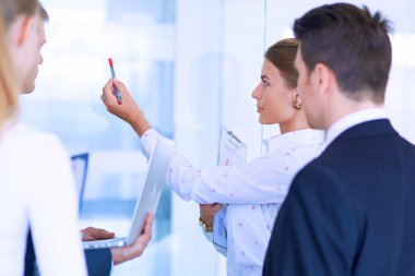 Toplantı sırasında dizüstü bilgisayarla sunum yapan bir grup iş adamı