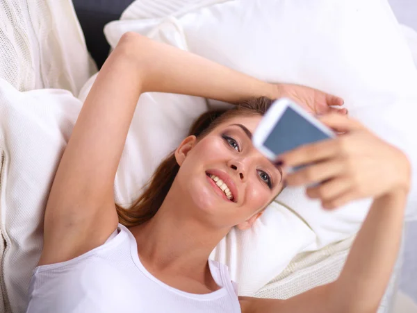 Glückliche Brünette macht ein Foto von sich mit ihrem Handy im Schlafzimmer — Stockfoto