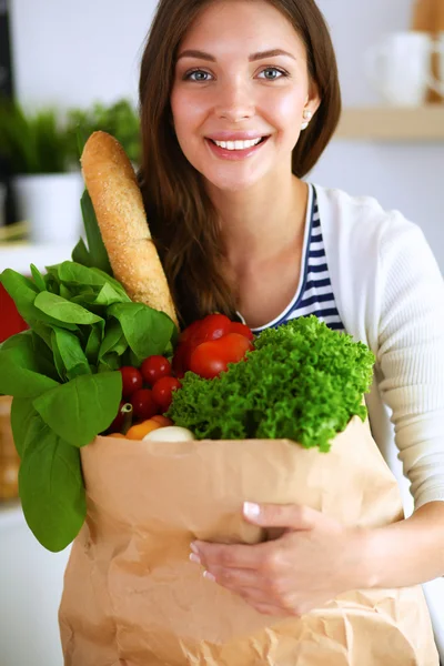 Junge Frau hält Einkaufstüte mit Gemüse — Stockfoto