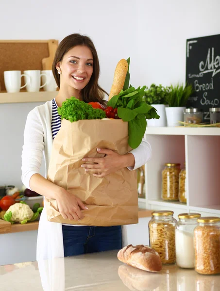 Young woman holding grocery shopping bag with vegetables — Stock Photo, Image