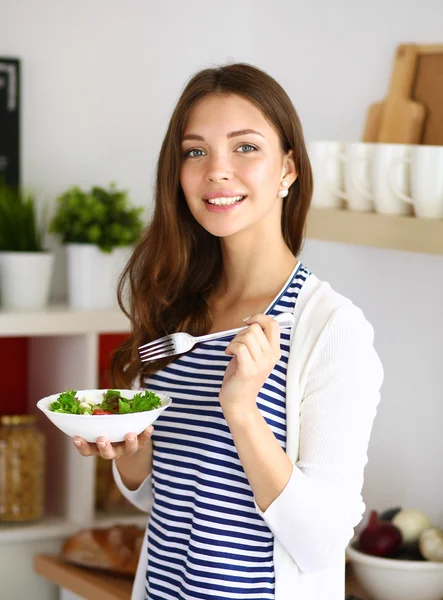 Ung kvinna äta sallad och hålla en blandad sallad — Stockfoto