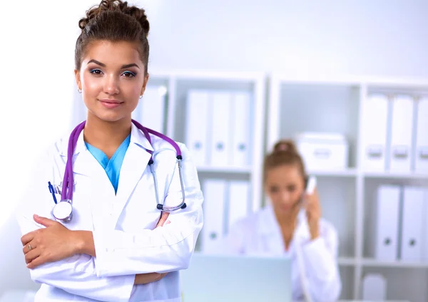 Retrato de una joven doctora con una bata blanca de pie en el hospital — Foto de Stock