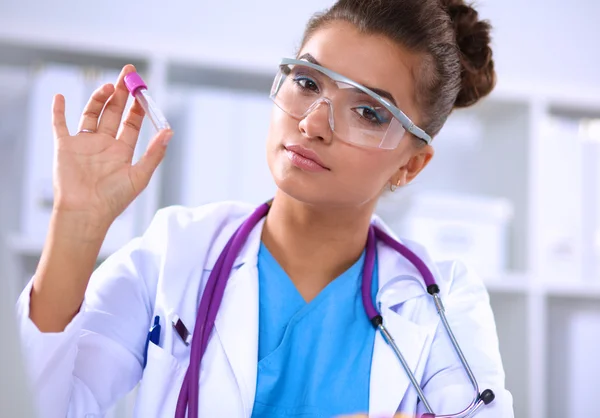 Woman researcher is surrounded by medical vials and flasks, isolated on white background — Stock Photo, Image