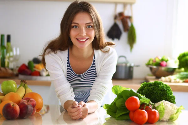 Jonge vrouw in de buurt van bureau in de keuken — Stockfoto