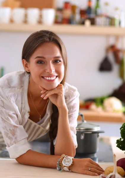 Junge Frau steht neben Schreibtisch in der Küche — Stockfoto