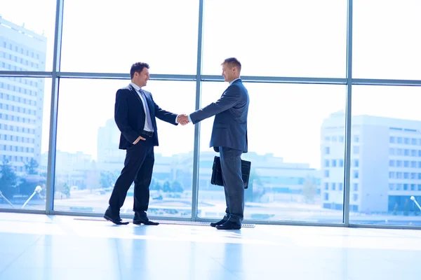 Imagen completa de dos exitosos hombres de negocios estrechándose la mano entre sí —  Fotos de Stock