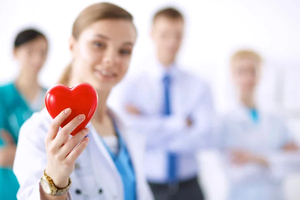 Female doctor with stethoscope holding heart — Stock Photo, Image