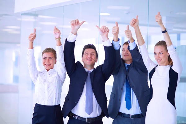 Happy business team showing thumbs up in office — Stock Photo, Image