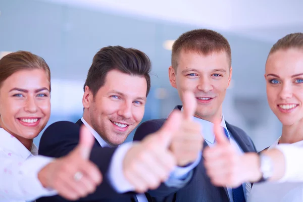 Equipe de negócios feliz mostrando polegares no escritório — Fotografia de Stock