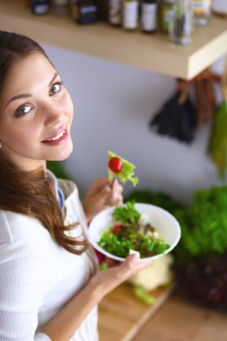 Salata yemek ve karışık salata tutan genç kadın 